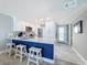 Modern kitchen with white cabinets, stainless steel appliances, and a stylish blue-accented island at 1100 Tarpon Center Dr # 503 5C, Venice, FL 34285