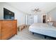 Relaxing main bedroom with TV, dresser, sitting bench, ceiling fan, and warm lighting at 1100 Tarpon Center Dr # 503 5C, Venice, FL 34285
