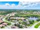 Aerial view of the Venetian Falls community, showcasing the lake, clubhouse, and residential areas at 11103 Batello Dr, Venice, FL 34292