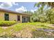Backyard view featuring a well-maintained lawn, landscaping, and the rear exterior of the home at 11103 Batello Dr, Venice, FL 34292