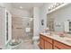 Bathroom featuring a glass-enclosed shower, toilet, and a vanity with double sinks and ample lighting at 11103 Batello Dr, Venice, FL 34292