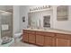 Bathroom with a double sink vanity, toilet, shower with glass door, and ample lighting at 11103 Batello Dr, Venice, FL 34292