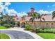Exterior of the Venetian Falls clubhouse with well-manicured landscaping and tiled roof at 11103 Batello Dr, Venice, FL 34292