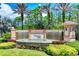 Venetian Falls community entrance with waterfall feature, lush landscaping, and towering palm trees at 11103 Batello Dr, Venice, FL 34292
