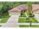 Beautiful aerial view of a home featuring lush landscaping, neutral colors, and a large driveway at 11103 Batello Dr, Venice, FL 34292