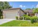 Charming single-story home with a tile roof, well-manicured lawn, and mature landscaping at 11103 Batello Dr, Venice, FL 34292
