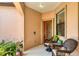Inviting front porch with potted plants and wicker furniture at 11103 Batello Dr, Venice, FL 34292
