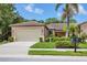 Charming home featuring a well-manicured lawn, lush landscaping, and a neutral colored exterior at 11103 Batello Dr, Venice, FL 34292