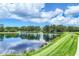 Scenic view of the lake with lush trees and a blue sky, ideal for serene walks and enjoying nature at 11103 Batello Dr, Venice, FL 34292
