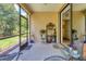 Open screened-in lanai space with comfortable seating and a view of the lush outdoor landscape at 11103 Batello Dr, Venice, FL 34292