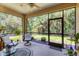 Cozy screened lanai offering outdoor seating and views of the green backyard and foliage at 11103 Batello Dr, Venice, FL 34292