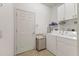 Clean laundry room with a washer and dryer, storage shelves, and a tiled floor at 11103 Batello Dr, Venice, FL 34292