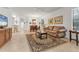 Inviting living room with tile flooring, a ceiling fan, and a view of the dining area at 11103 Batello Dr, Venice, FL 34292