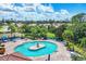Aerial view of community pool with fountain, surrounded by palm trees, lounge chairs and tables with umbrellas at 11103 Batello Dr, Venice, FL 34292