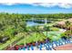 Stunning lakefront views from the pool with lush landscaping and a putting green, under a beautiful blue sky at 11103 Batello Dr, Venice, FL 34292