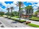 Scenic street view lined with palm trees and meticulously maintained landscaping leading to Venetian Falls at 11103 Batello Dr, Venice, FL 34292