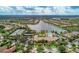 An aerial shot showcases a lakefront community featuring lush landscaping and recreational amenities at 11624 Garessio Ln, Sarasota, FL 34238