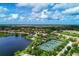 Beautiful aerial view of the community featuring tennis courts, lake and lush landscaping at 11624 Garessio Ln, Sarasota, FL 34238