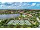 Aerial view showcasing the community's lake, swimming pool, playground, and tennis courts at 11624 Garessio Ln, Sarasota, FL 34238