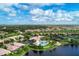 Aerial view displays an aquatic center, tennis court, nearby lake, and neighborhood homes at 11624 Garessio Ln, Sarasota, FL 34238