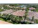 A high angle view showcases homes with lush landscaping, palm trees and a serene lake at 11624 Garessio Ln, Sarasota, FL 34238