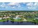 An aerial view of the community featuring a pool, clubhouse, and lake in a lush, tropical setting at 11624 Garessio Ln, Sarasota, FL 34238
