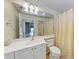 Bathroom with a white sink vanity, large mirror, and shower with a curtain at 11624 Garessio Ln, Sarasota, FL 34238