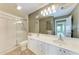 Bright bathroom with a double sink vanity, large mirror, and walk-in shower at 11624 Garessio Ln, Sarasota, FL 34238
