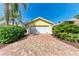 Detached one car garage with red and tan brick paver driveway and mature tropical landscaping at 11624 Garessio Ln, Sarasota, FL 34238