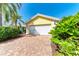 Detached one car garage with red and tan brick paver driveway and tropical landscaping at 11624 Garessio Ln, Sarasota, FL 34238