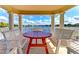 View from lakeside gazebo showing outdoor seating with beautiful lake and blue sky at 11624 Garessio Ln, Sarasota, FL 34238