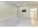 Expansive living area with neutral walls, modern ceiling fan and doorway leading to the main bedroom at 11624 Garessio Ln, Sarasota, FL 34238