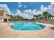 Community pool area featuring a large pool, plenty of seating, and lush palm trees at 11624 Garessio Ln, Sarasota, FL 34238