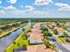 Stunning aerial view showcasing waterfront homes in a community with lush landscaping and mature trees at 11986 Granite Woods Loop, Venice, FL 34292