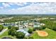 Aerial view of the community featuring lakes, tennis courts, a pool, and green spaces in a scenic setting at 11986 Granite Woods Loop, Venice, FL 34292