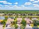 Aerial view of a two-story home with lush greenery, a pond, and a serene neighborhood at 11986 Granite Woods Loop, Venice, FL 34292