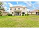 Lush green backyard with ample space, complemented by the home's inviting exterior and screen lanai at 11986 Granite Woods Loop, Venice, FL 34292
