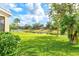 Expansive grassy backyard offering serene water views, enhanced by mature trees at 11986 Granite Woods Loop, Venice, FL 34292