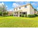 Spacious backyard with a lush green lawn and a screened patio that's ideal for entertaining at 11986 Granite Woods Loop, Venice, FL 34292