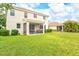 Spacious backyard featuring green grass, exterior of the home, and a screened in lanai at 11986 Granite Woods Loop, Venice, FL 34292