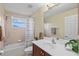 Bathroom with a combined shower and bathtub with neutral tile and cherrywood vanity at 11986 Granite Woods Loop, Venice, FL 34292