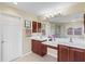 Bright bathroom with double sinks, tile floors, and large mirror with vanity lighting at 11986 Granite Woods Loop, Venice, FL 34292