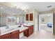 Bright bathroom with double sinks, tile floors, and connecting door to the Primary bedroom at 11986 Granite Woods Loop, Venice, FL 34292