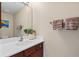 Well-lit half bathroom features a single sink vanity with bronze fixtures and neutral paint at 11986 Granite Woods Loop, Venice, FL 34292
