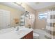 Bright bathroom featuring a vanity, framed mirror, and tub-shower combo with neutral tile at 11986 Granite Woods Loop, Venice, FL 34292