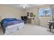 Sunlit bedroom with large window, desk, and a unique blue patterned comforter on the bed at 11986 Granite Woods Loop, Venice, FL 34292