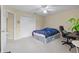Bright bedroom featuring a white closet, ceiling fan, and modern bed with dark blue sheets at 11986 Granite Woods Loop, Venice, FL 34292