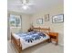 Cozy bedroom with a bright window and wooden bed frame with blue flower design bedding at 11986 Granite Woods Loop, Venice, FL 34292