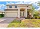 Two-story home featuring a two-car garage, a welcoming front porch, and a well-manicured lawn with beautiful landscaping at 11986 Granite Woods Loop, Venice, FL 34292