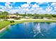Community clubhouse exterior showcasing a well-maintained building, pond with fountain, and landscaped grounds at 11986 Granite Woods Loop, Venice, FL 34292